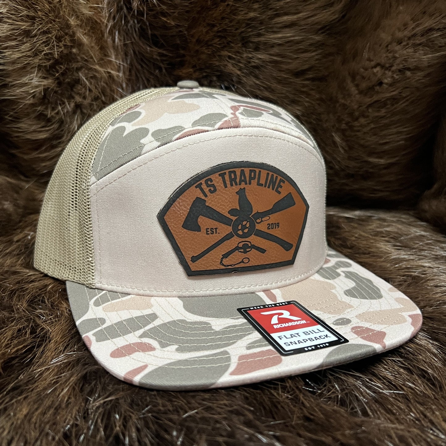 Richardson 7 Panel Camo Mesh Back Trucker w/ Ax & Rifle “Tombstone” Leather patch