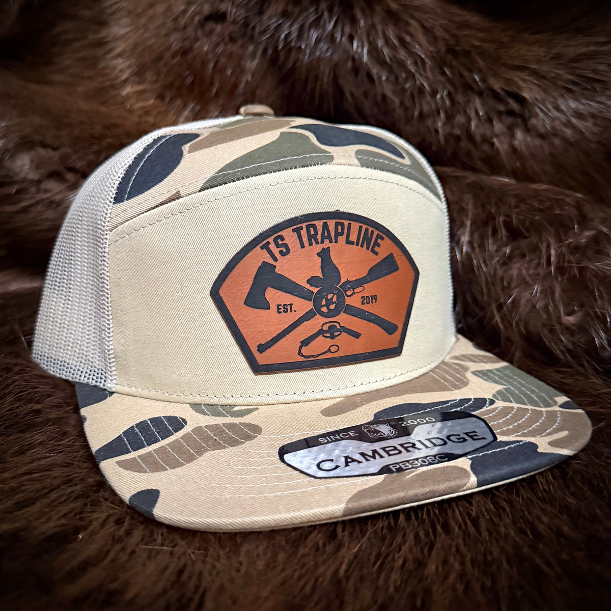 7 Panel Camo Mesh Back Trucker w/ Ax & Rifle “Tombstone” Leather patch